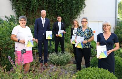 Bild vergr��ern: Bei sommerlichem Wetter pr�sentieren Seniorenberaterin Bettina Gro�haus-Lutz (Neunkirchen) B�rgermeister Christoph Ewers (Burbach),  B�rgermeister Dr. Bernhard Baumann (Neunkirchen), B�rgermeisterin Christa Schuppler (Wilnsdorf),  Seniorenberaterin Jutta Schmidt (Wilnsdorf) und Seniorenberaterin Birgit Meier-Braun (Burbach) den neu aufgelegten Seniorenwegweiser S�dliches Siegerland (v.l.n.r).