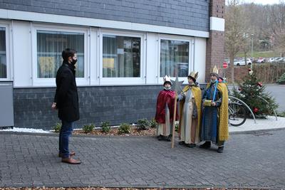 Bild vergr��ern: Als symbolischer Auftakt f�r eine in diesem Jahr etwas andere Spendenaktion besuchten die Sternsinger der kath. Kirchengemeinde St. Martinus Wilnsdorf B�rgermeister Hannes Gieseler vor dem Wilnsdorfer Rathaus (stellvertretend f�r alle H�user in Wilnsdorf), wo sie den Segen �berbrachten und eine Spende entgegennahmen.