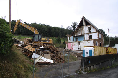 Bild vergr��ern: Ein Bagger rei�t zurzeit das Doppelhaus in der Niederdielfer Stra�e "Am Buchen 9-11" ab, das die Gemeinde Wilnsdorf seit 1980 zur Unterbringung von Gefl�chteten und Menschen ohne Obdach genutzt hat.