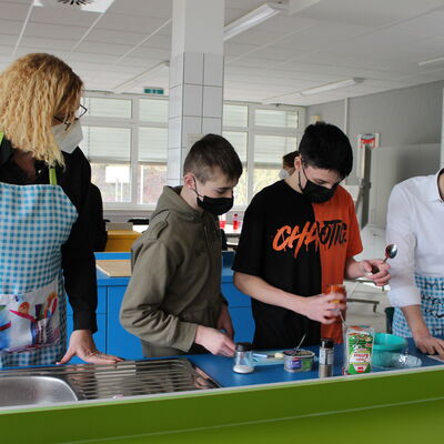 Bild vergr��ern: Beim offiziellen Einweihungskochen der neuen Lehr- und Lernk�che der Hauptschule zauberte die Klasse 9a leckere Pizzab�llchen. Dazu gab es einen �Drachen�-Dipp, bei dessen Zubereitung B�rgermeister Hannes Gieseler selbst den Kochl�ffel schwang.