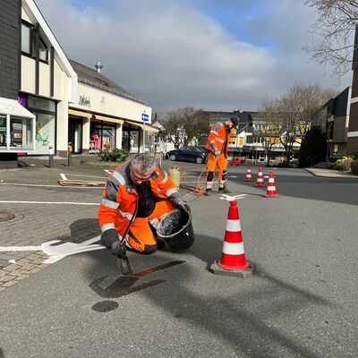 Bild vergr��ern: Die Kollegen des Bauhofes bringen Fu�g�nger-Symbolbilder auf die Fahrbahn am Marktplatz auf.