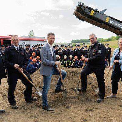Bild vergr��ern: Im Beisein von Vertretern aus Politik und Feuerwehr setzten Einheitsf�hrer Torsten Stein (2.v.l.), B�rgermeister Hannes Gieseler (3.v.l.) und Feuerwehrleiter Christian Rogalski (4.v.l.) den symbolischen ersten Spatenstich f�rs neue Feuerwehrger�tehaus Oberes Wei�tal.
