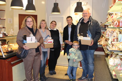 B�rgermeister Hannes Gieseler (2.v.r.) �bergibt Pr�sentk�rbe an die Gewinnerinnen der Aktion �Heimat shoppen�: Dina Zwiorek (l.), Steffi G�bel (2.v.l.) und Andr� Meyer mit Sohn (r.). Mit dabei: Marlen Falk (Mitte), Gesch�ftsf�hrung Caf� �Kaffeeduft�